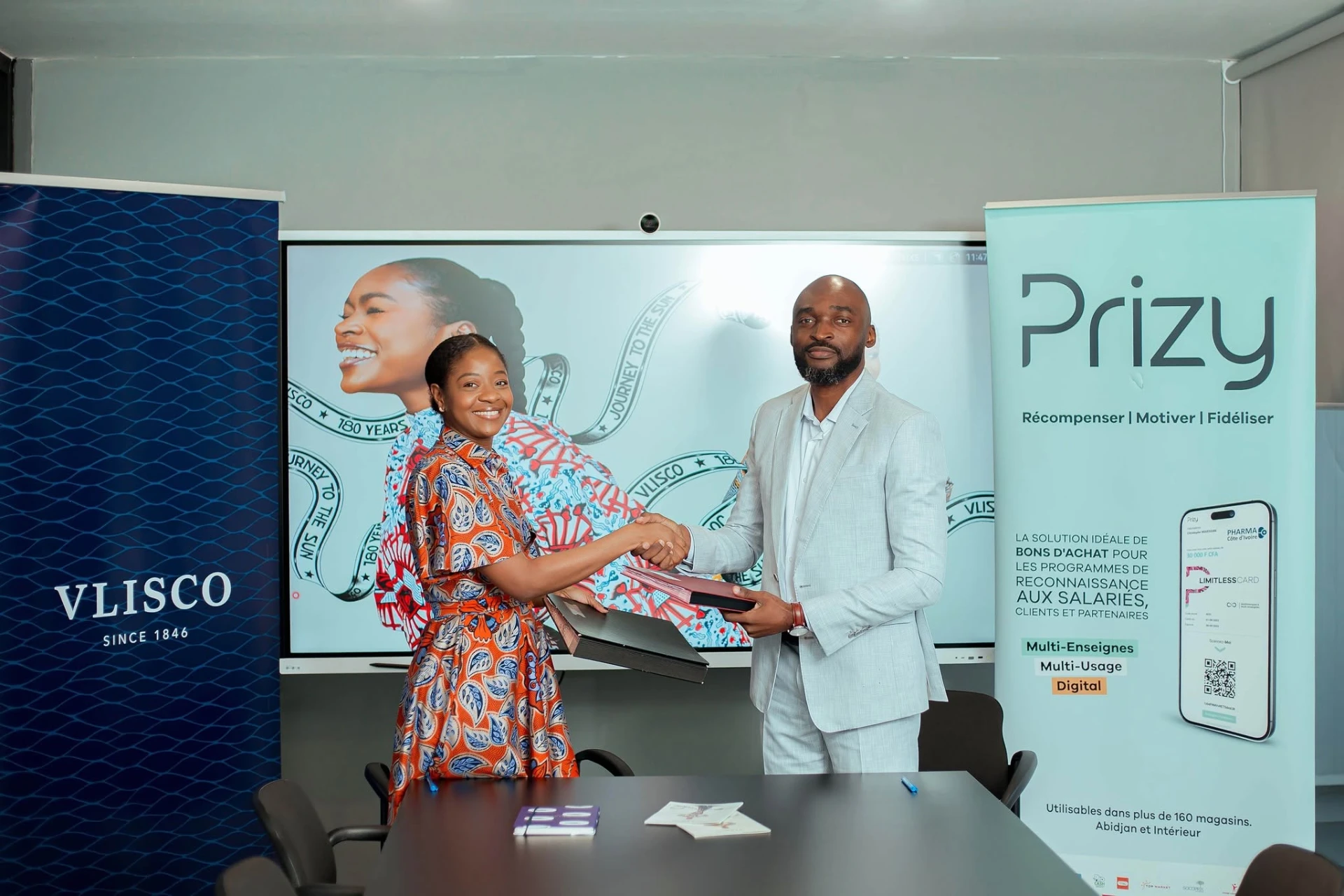 Poignée de main entre les représentants de Vlisco et de Prizy Côte d’Ivoire après la signature
